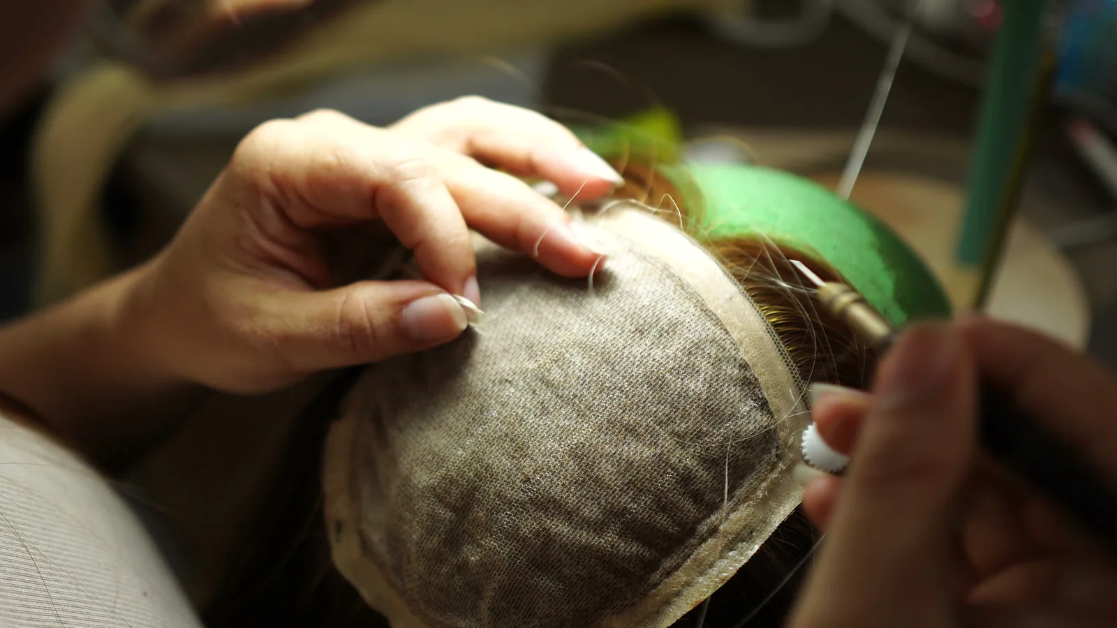 Wigs Vietnam artisan hand-tying hair into a lace wig cap