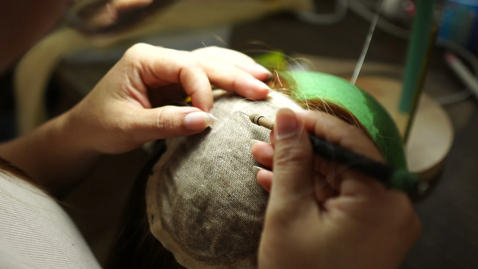 Close-up of a hand-tied toupee hairline showing single-knot ventilation