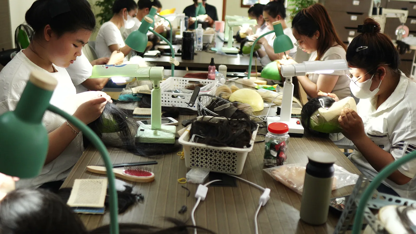 Wigs Vietnam artisans hand-tying wigs in the Khanh Hoa workshop